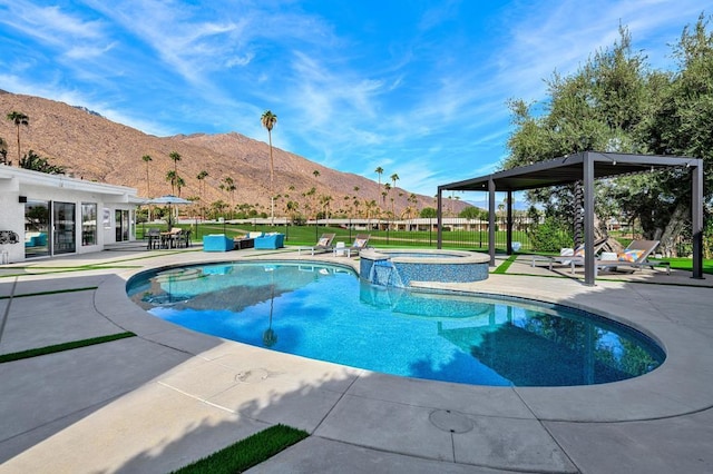 view of pool featuring a patio area, an in ground hot tub, and a mountain view