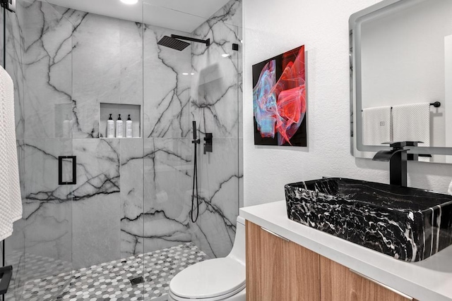 bathroom with vanity, toilet, and a shower with shower door