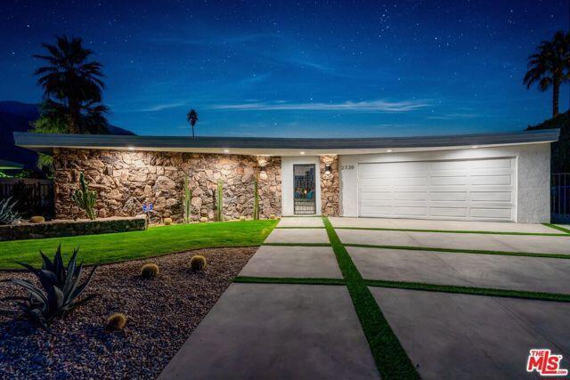 ranch-style house featuring a front yard and a garage