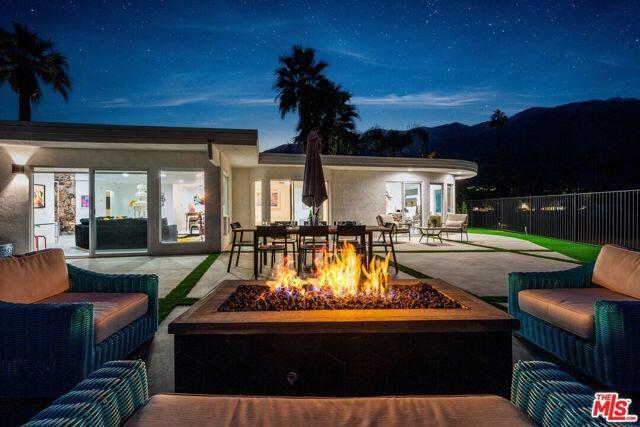 patio terrace at dusk featuring an outdoor living space with a fire pit