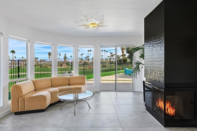 living room with a textured ceiling, ceiling fan, and a fireplace