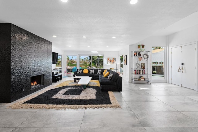 living room featuring a tile fireplace and a healthy amount of sunlight