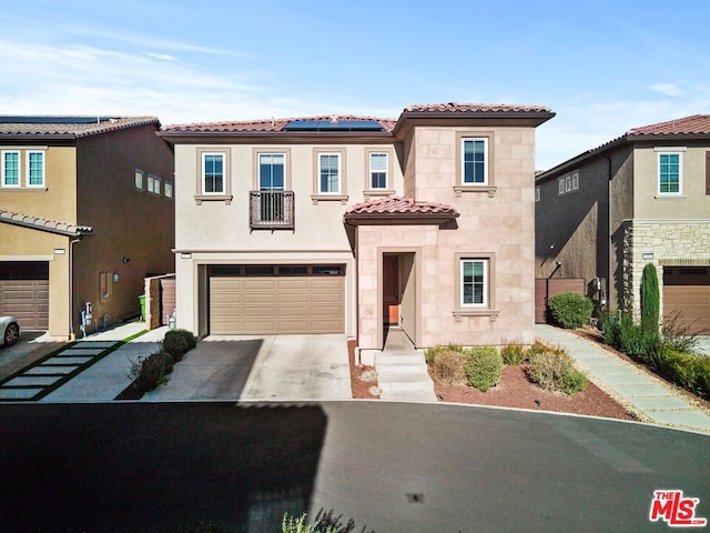 mediterranean / spanish-style home with a garage and solar panels