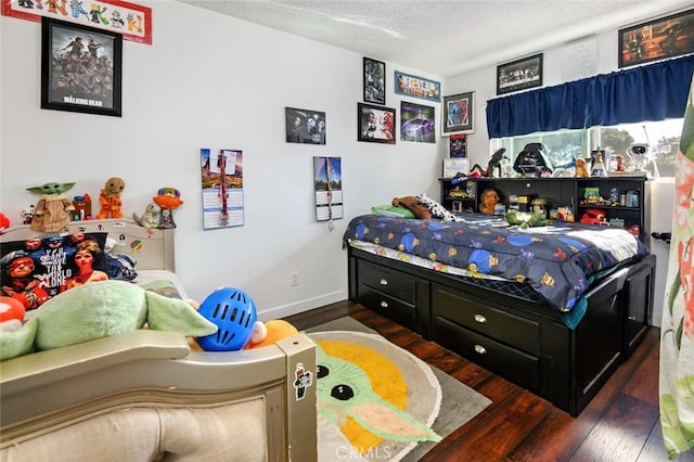 bedroom featuring dark wood-type flooring and a textured ceiling