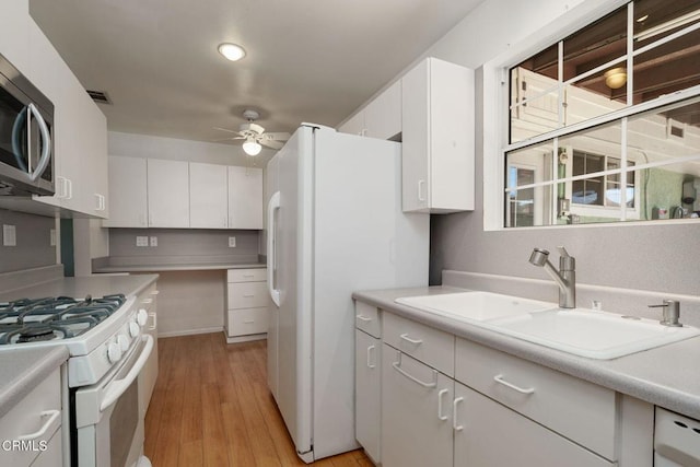 kitchen with white cabinets, ceiling fan, white appliances, and sink