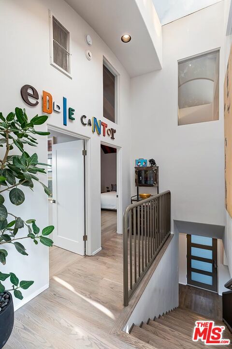 stairs featuring wood-type flooring and a high ceiling