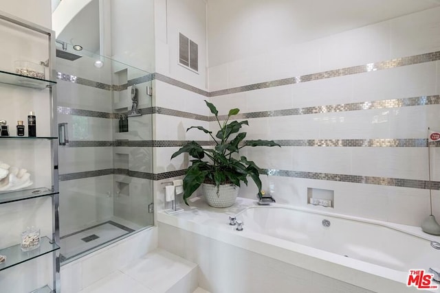 bathroom featuring shower with separate bathtub