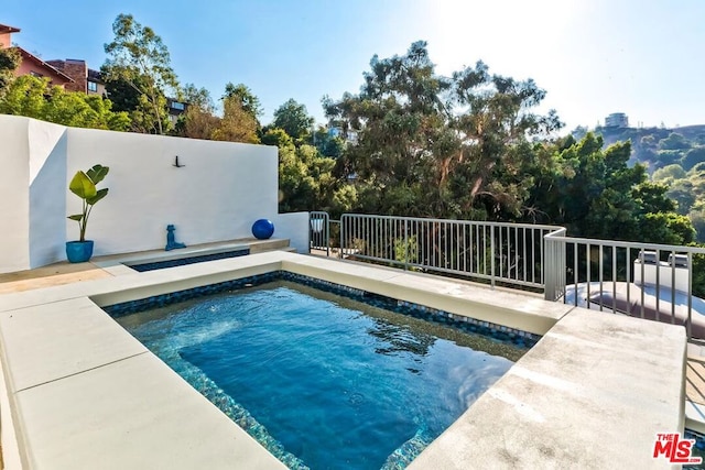 view of swimming pool featuring a jacuzzi