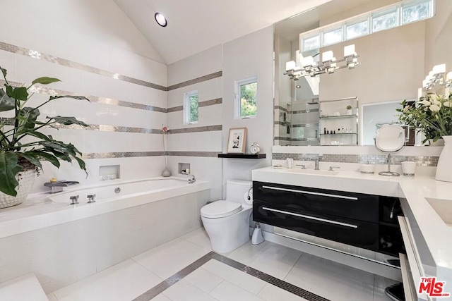 bathroom featuring a bathtub, vanity, vaulted ceiling, tile patterned flooring, and toilet