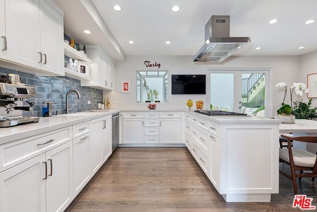 kitchen featuring island exhaust hood, white cabinetry, kitchen peninsula, and light hardwood / wood-style floors