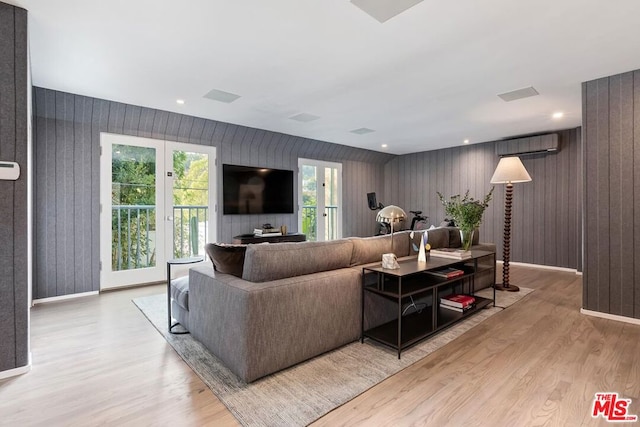 living room featuring wooden walls and light hardwood / wood-style flooring