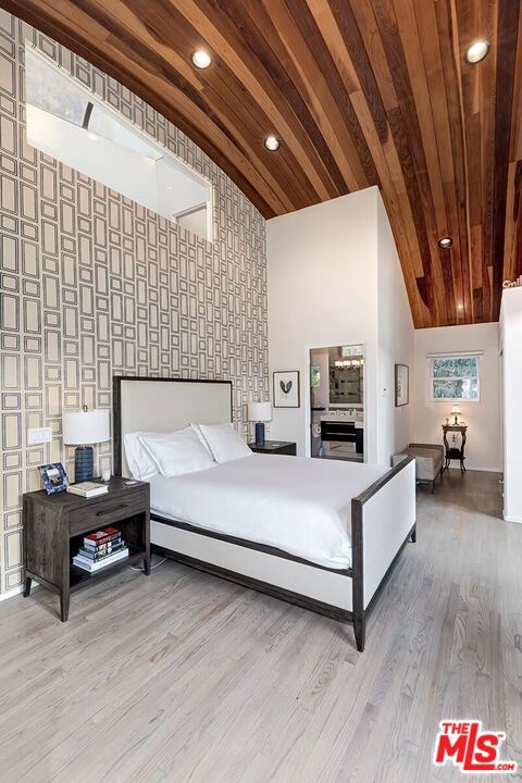 bedroom featuring light hardwood / wood-style floors, wooden ceiling, and vaulted ceiling