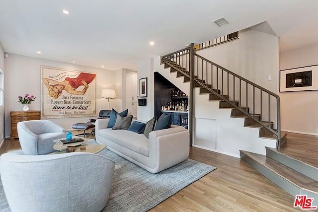 living room featuring bar area and hardwood / wood-style floors