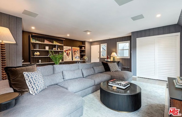 living room featuring hardwood / wood-style floors and wood walls