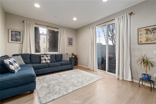 living room with light wood-type flooring, baseboards, and recessed lighting