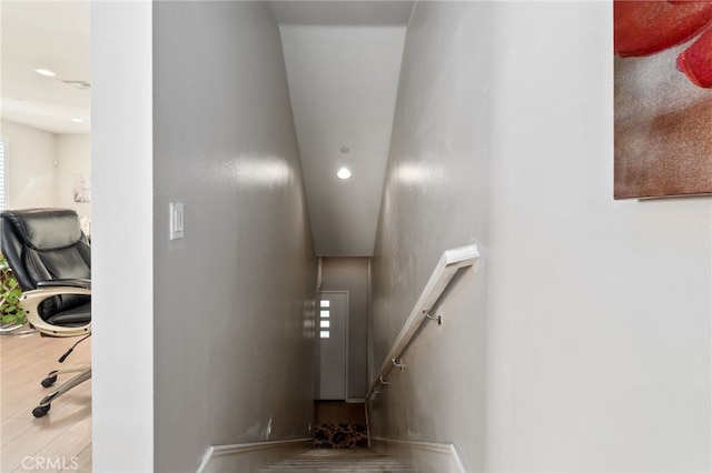 stairway with wood finished floors and baseboards