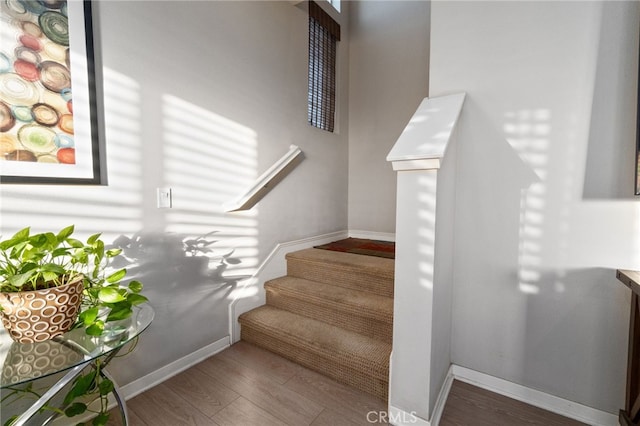 stairway featuring baseboards and wood finished floors