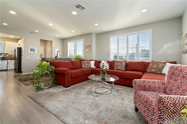 living room featuring recessed lighting, visible vents, and light wood finished floors