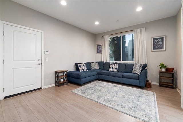 living area featuring light wood-style floors, baseboards, and recessed lighting