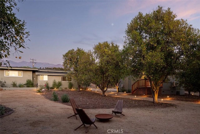 yard at dusk featuring an outdoor fire pit