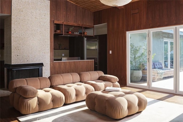 living room featuring wood ceiling, a fireplace, and wooden walls