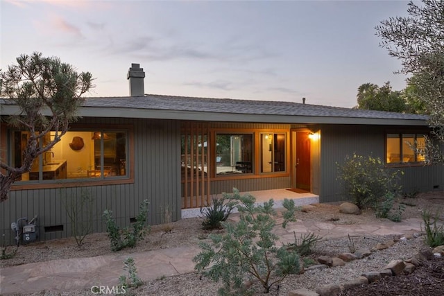 view of back house at dusk