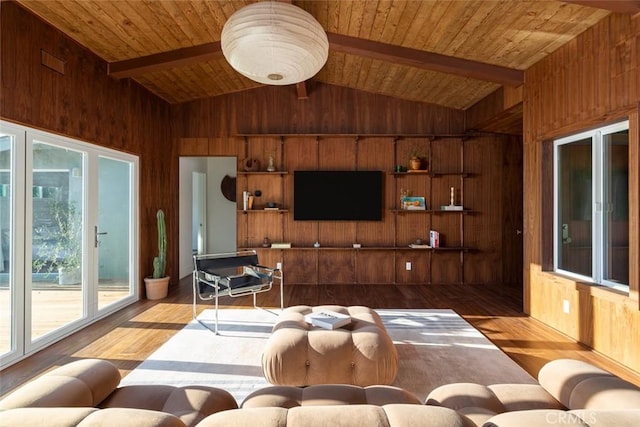 living room with vaulted ceiling with beams and wood walls