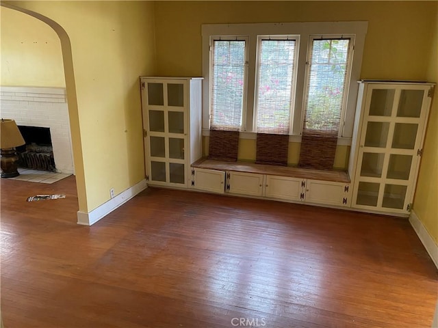 unfurnished room featuring light hardwood / wood-style flooring and a brick fireplace