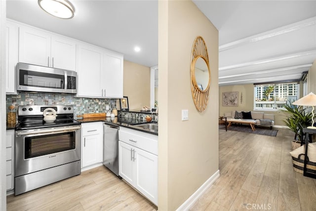 kitchen featuring stainless steel appliances, sink, white cabinetry, light hardwood / wood-style flooring, and backsplash