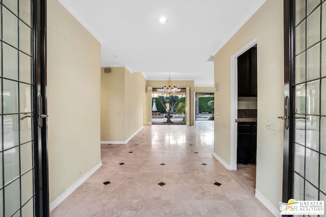 hallway featuring a chandelier and ornamental molding