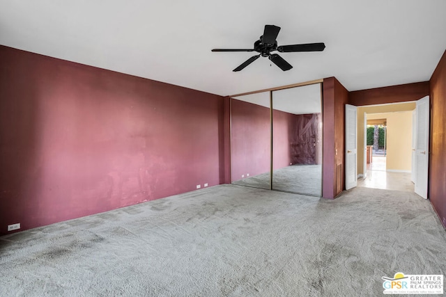 unfurnished bedroom with ceiling fan, a closet, and light colored carpet