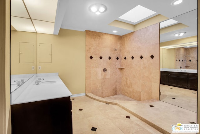 bathroom with tile patterned floors, vanity, tiled shower, and a skylight