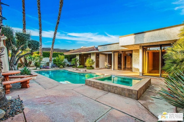 view of swimming pool featuring an in ground hot tub and a patio area