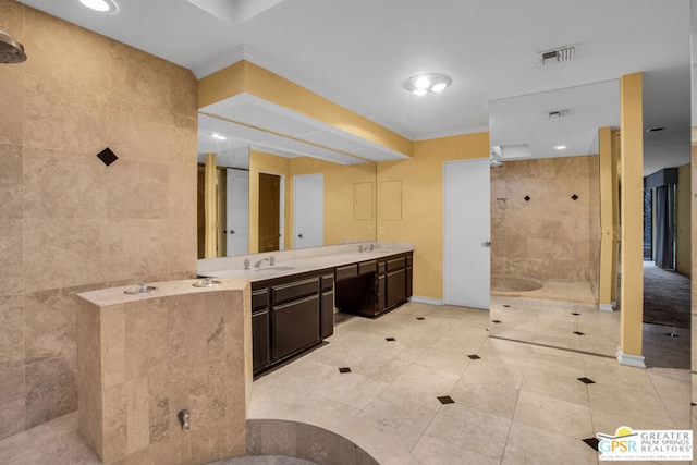 bathroom featuring vanity, a tile shower, and tile walls