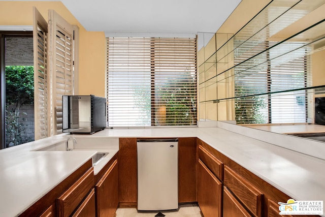 kitchen featuring stainless steel refrigerator, sink, and a healthy amount of sunlight