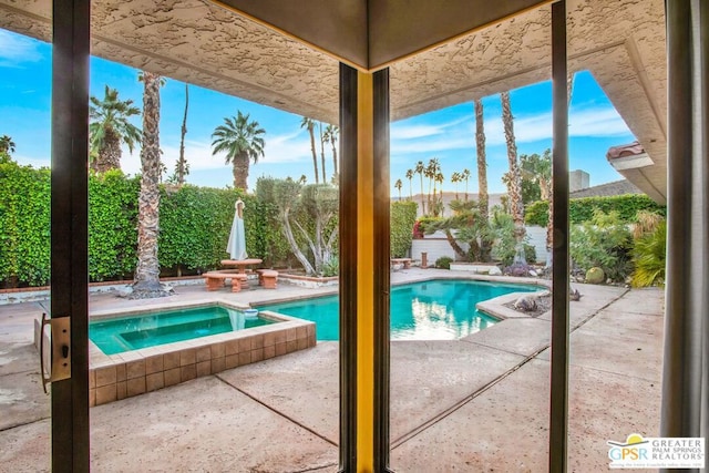 view of swimming pool with a patio area and an in ground hot tub