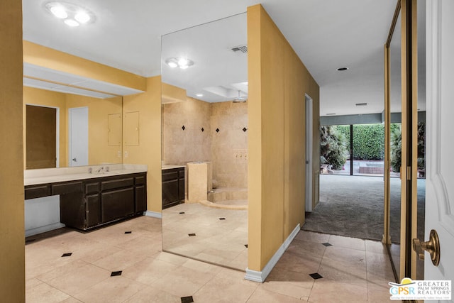 bathroom featuring tile patterned flooring, vanity, and a bath