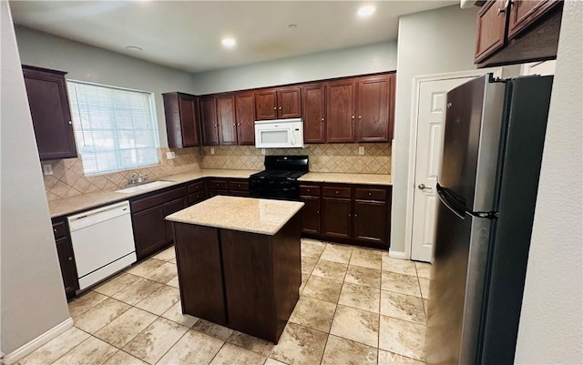 kitchen with sink, white appliances, decorative backsplash, and a kitchen island