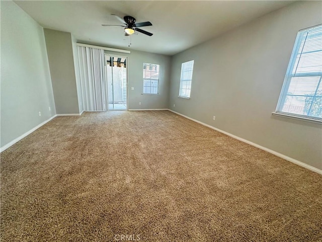 carpeted spare room with ceiling fan