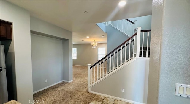 staircase with an inviting chandelier and carpet flooring