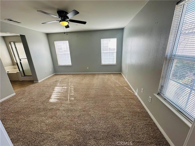 spare room featuring light carpet, ceiling fan, and a healthy amount of sunlight