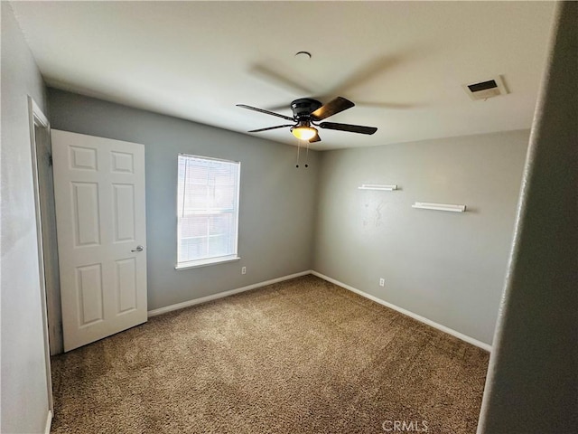 carpeted spare room featuring ceiling fan