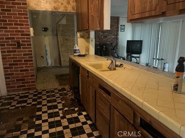 kitchen with dishwasher, tile countertops, and sink