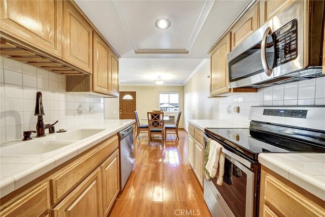 396 S Miraleste Dr Unit 512, San Pedro, CA 90732 - kitchen with a raised ceiling, appliances with stainless steel finishes, ornamental molding, light wood-type flooring, and a sink