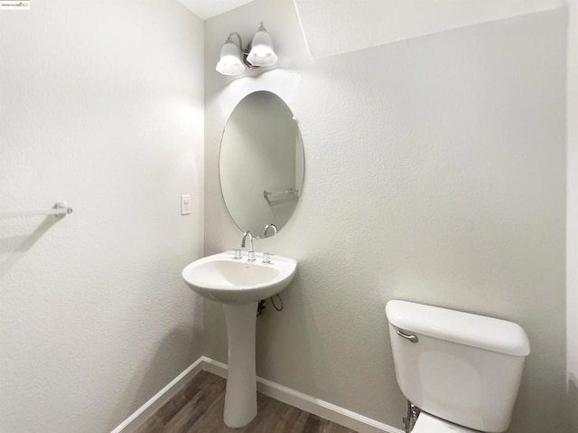 bathroom featuring toilet and wood-type flooring