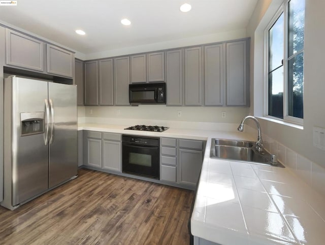 kitchen with gray cabinets, black appliances, and sink