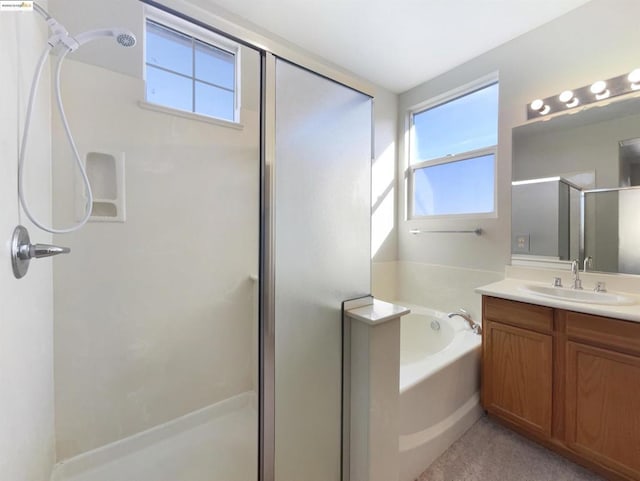 bathroom featuring plus walk in shower, a wealth of natural light, and vanity