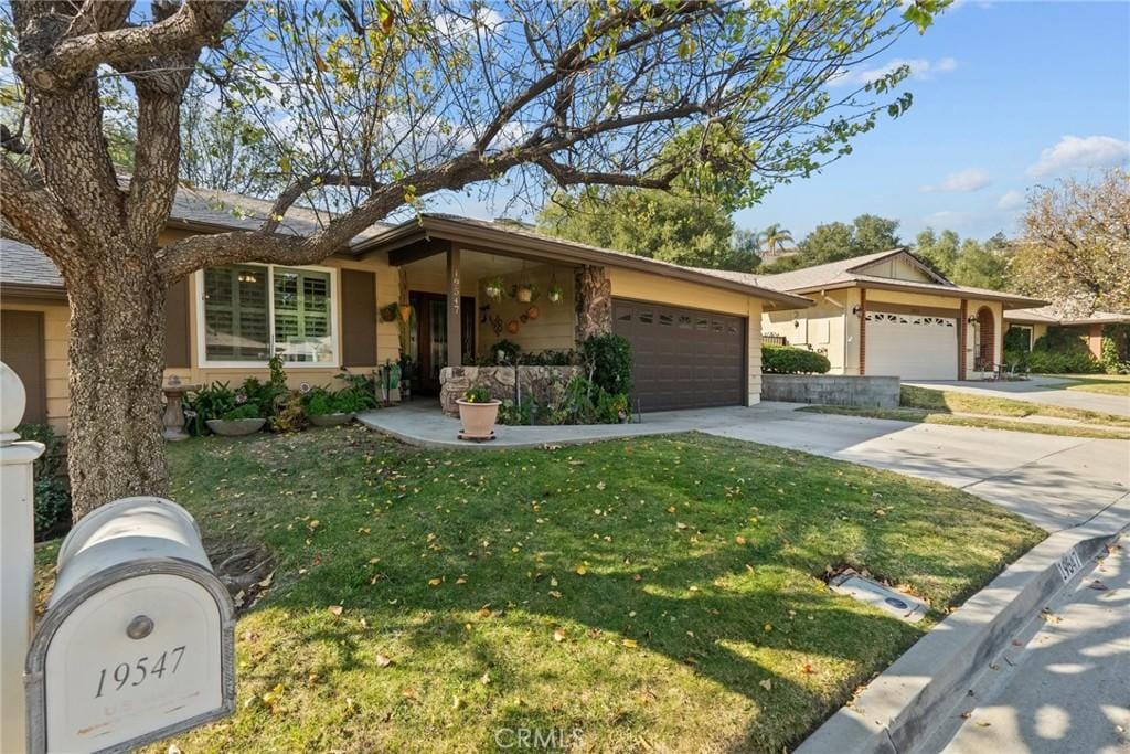 ranch-style house featuring a garage and a front lawn