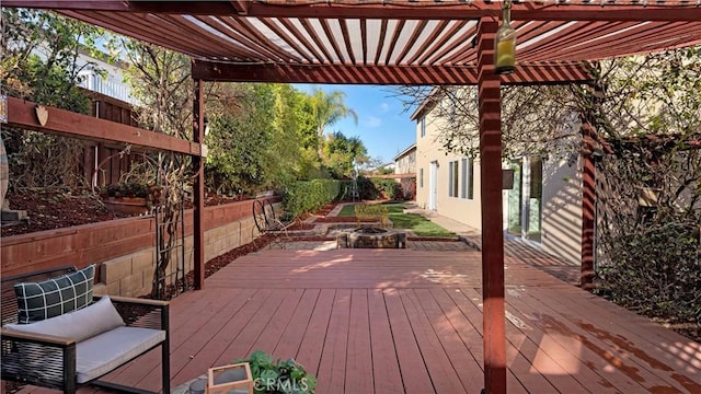 wooden terrace with an outdoor fire pit and a pergola