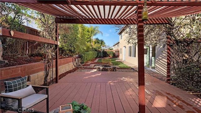 wooden deck featuring a pergola, an outdoor fire pit, and fence